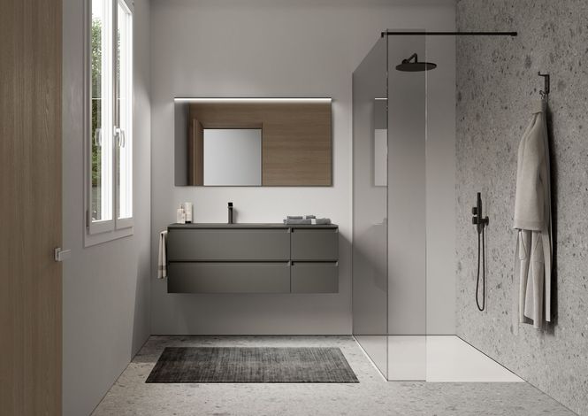 Une salle de bain avec lavabo, miroir et douche à l'italienne.
