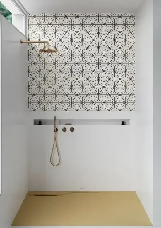 Une salle de bain avec douche et un motif géométrique sur le mur.