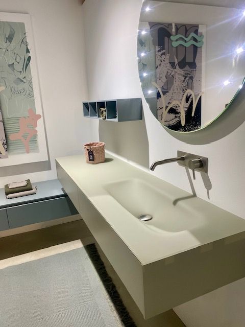Une salle de bain avec un lavabo et un miroir rond