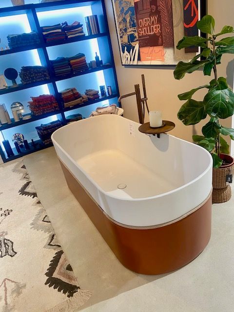 Une baignoire est placée dans une salle de bain à côté d'une plante.