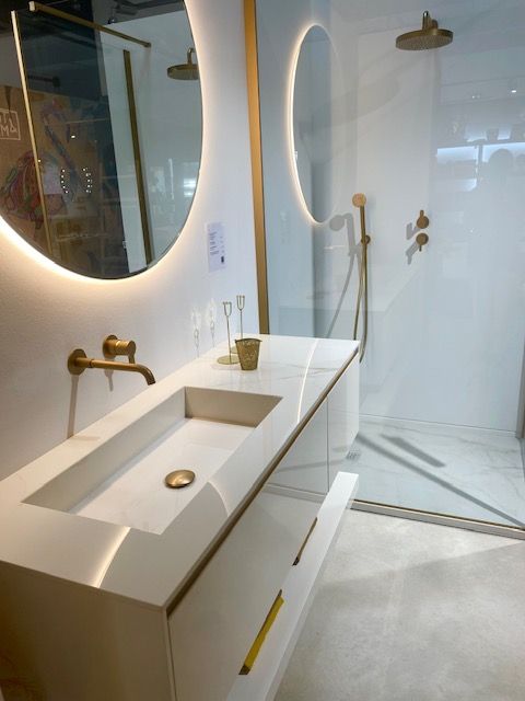 Une salle de bain avec un lavabo un miroir et une douche à l'italienne