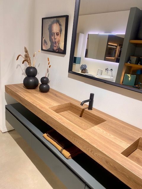 Une salle de bain avec deux lavabos et un miroir