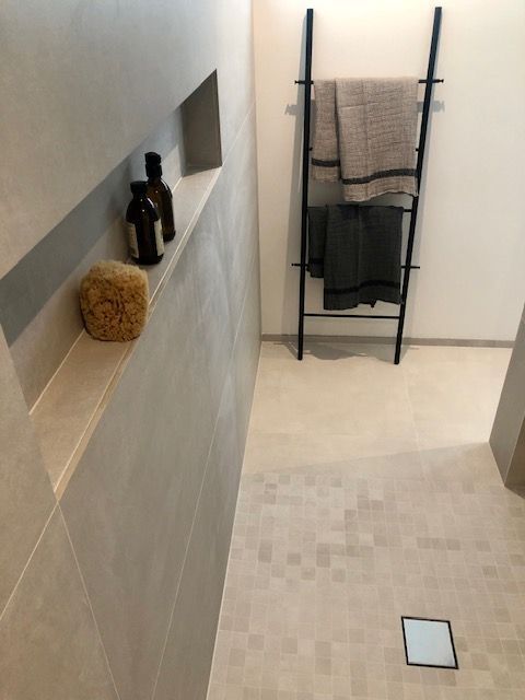 Une salle de bain avec une échelle et des serviettes dessus