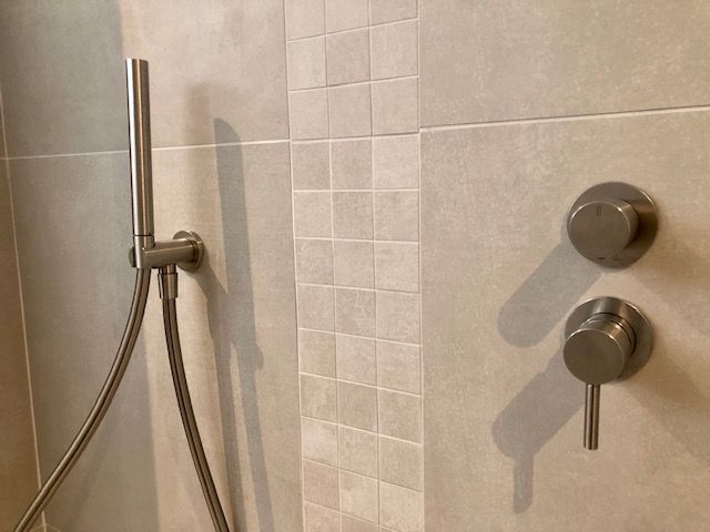 Un gros plan d'une pomme de douche dans une salle de bain.