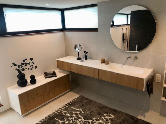 Une salle de bain avec un lavabo et un miroir rond