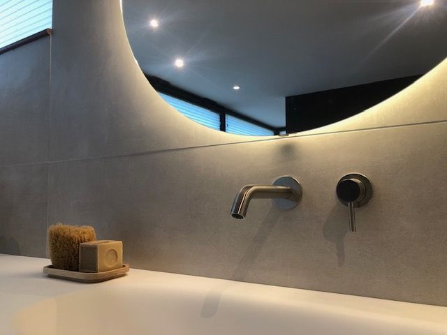 Un lavabo de salle de bain avec un miroir rond au-dessus