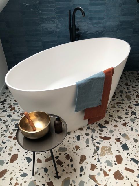 Une salle de bain avec une baignoire et un bol sur une table