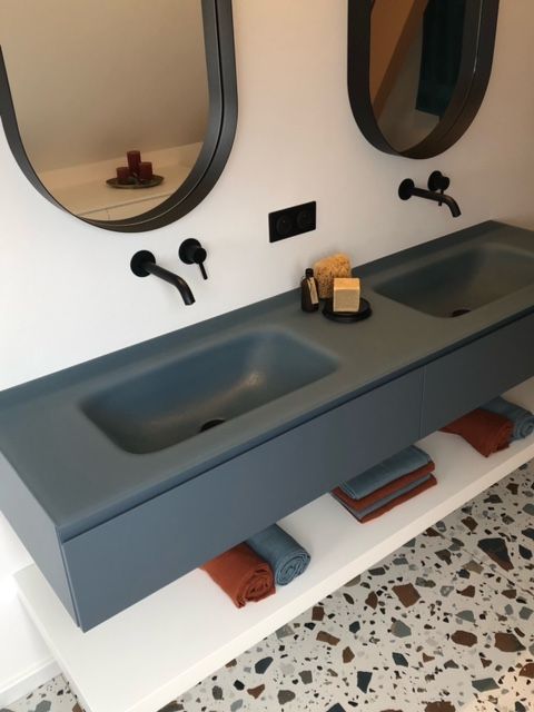 Une salle de bain avec deux lavabos et deux miroirs