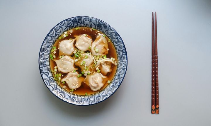 Stir fry egg noodles with chicken, sweet paprika, mushrooms, chives and sesame seeds in bowl. Asian cuisine dish.