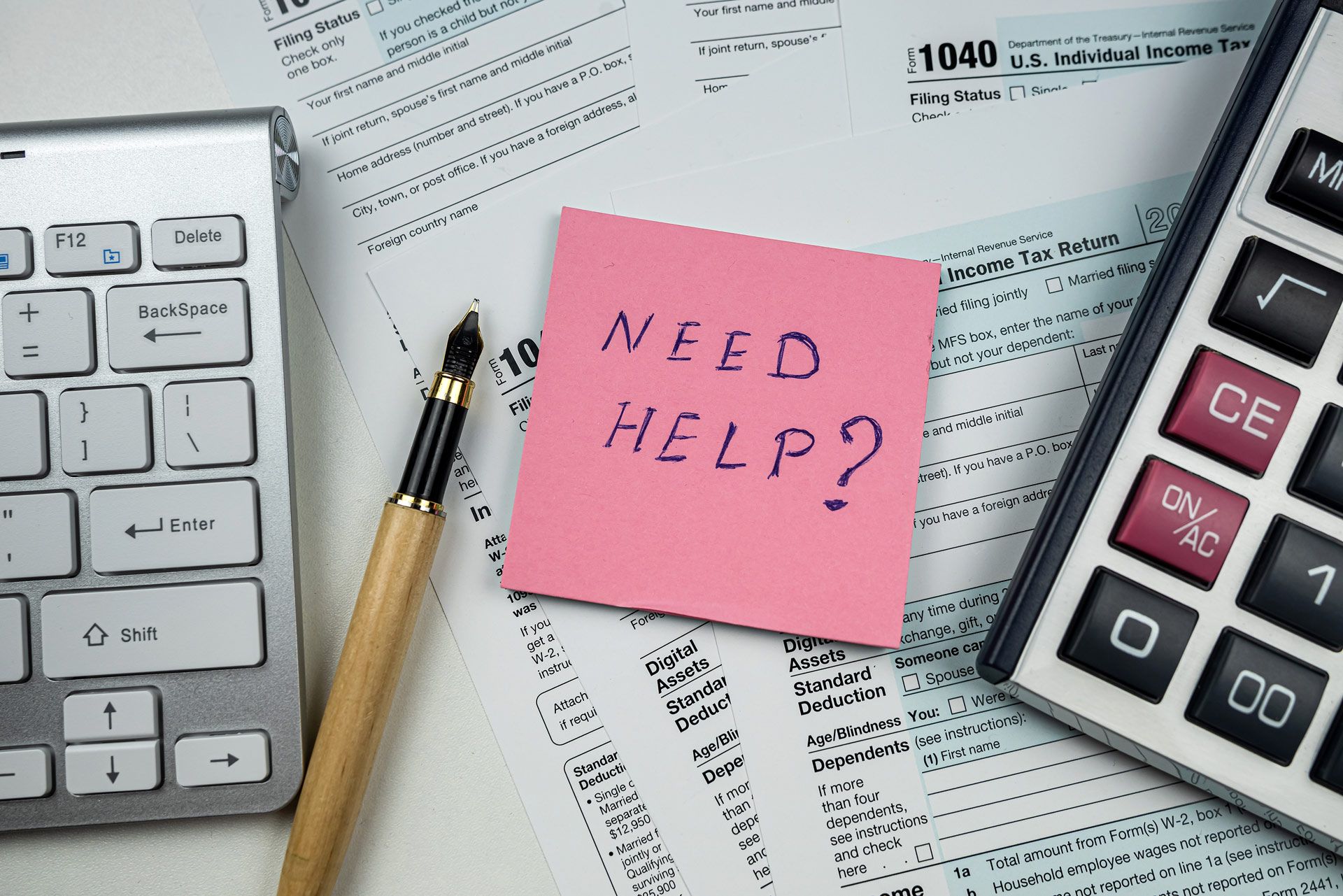 Hands writing on paperwork with a pen, a coffee mug, and money visible on a desk.