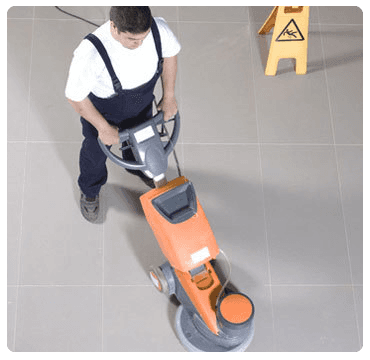 a man using a floor polisher in a commercial premises