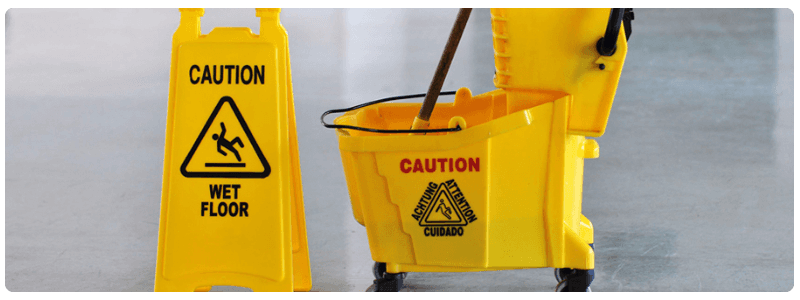 A mop and bucket next to a wet floor sign
