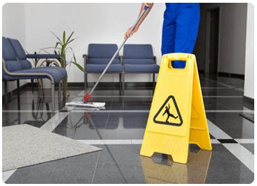 a wet floor sign next to someone mopping
