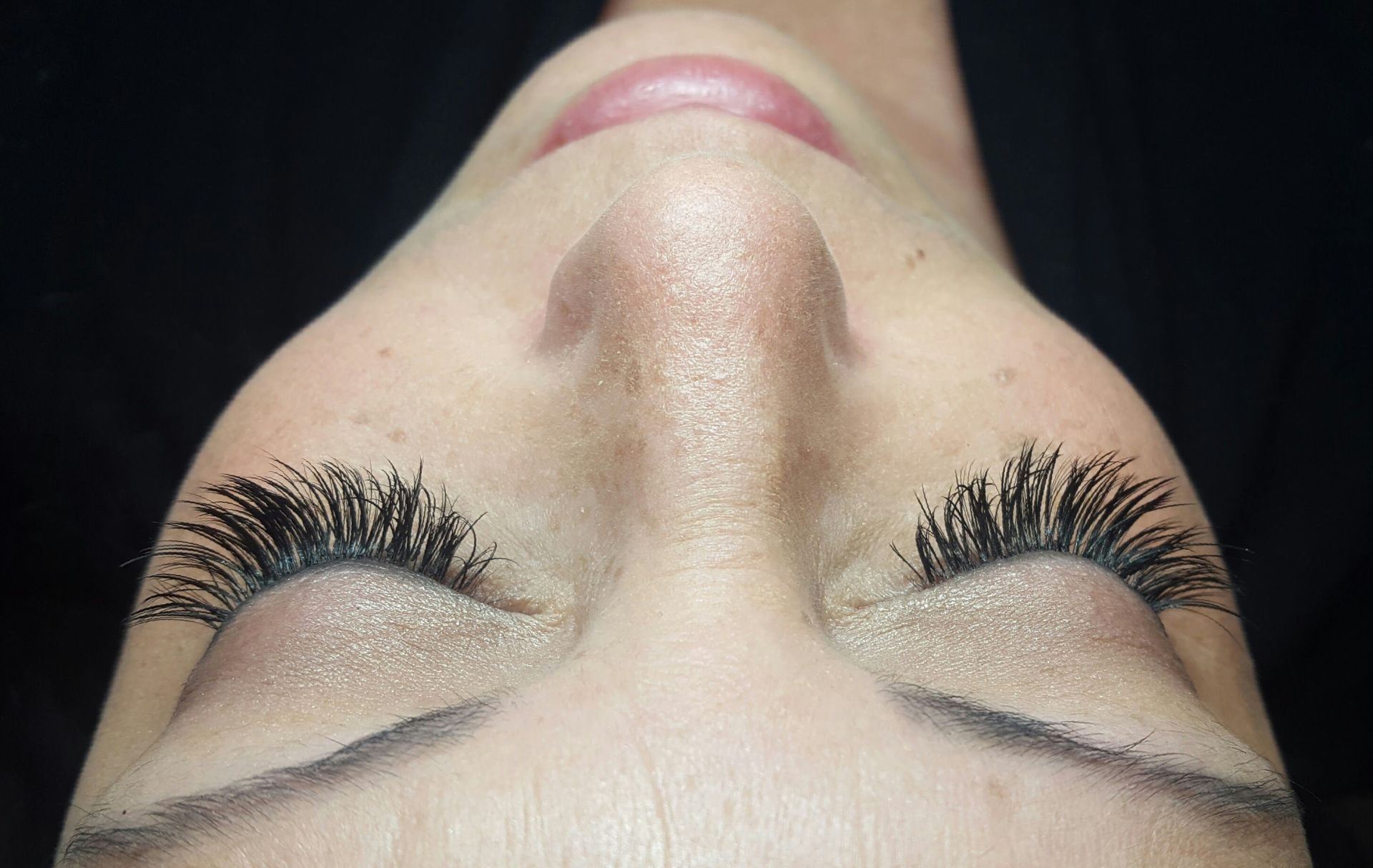 A close up of a woman 's face with her eyes closed