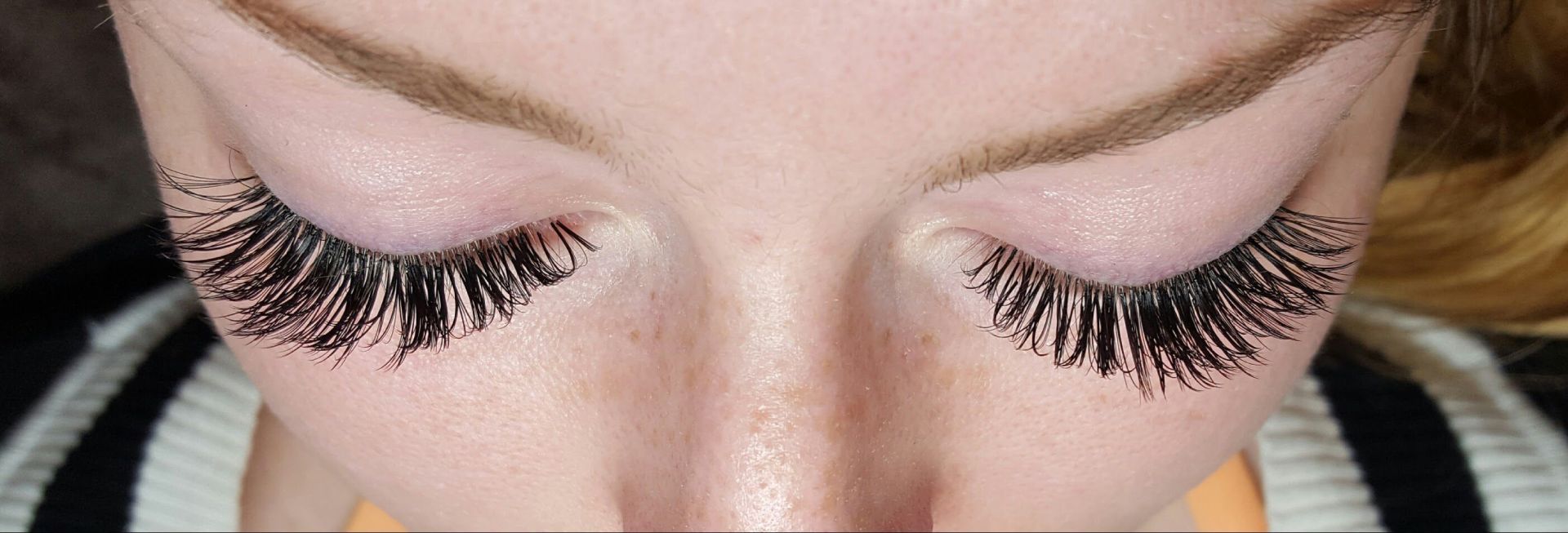 A close up of a woman 's eyes with long eyelashes.