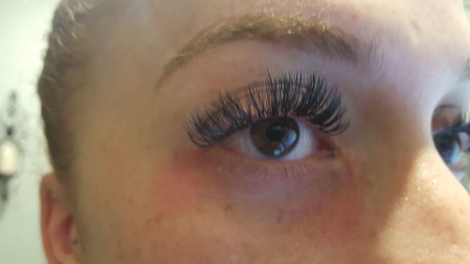 A close up of a woman 's eye with long eyelashes.