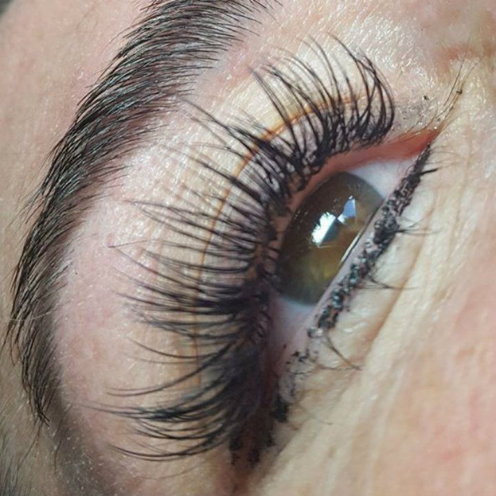 A close up of a woman 's eye with long eyelashes