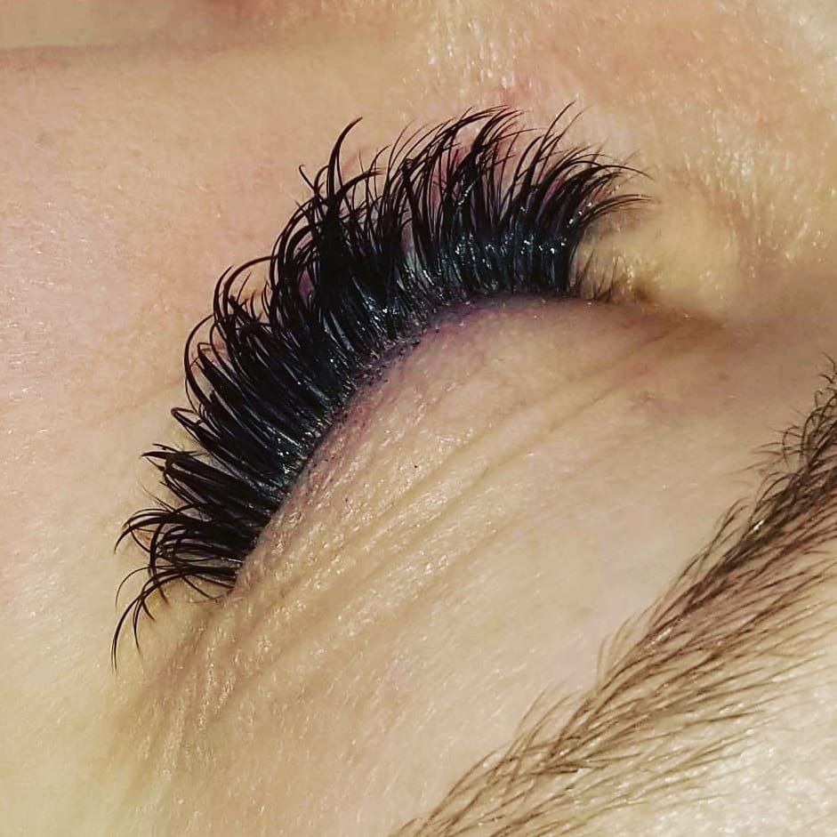 A close up of a woman 's eye with long eyelashes.