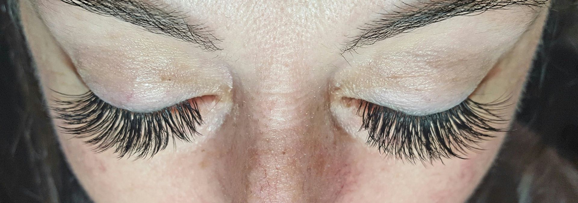 A close up of a woman 's eyes with long eyelashes.