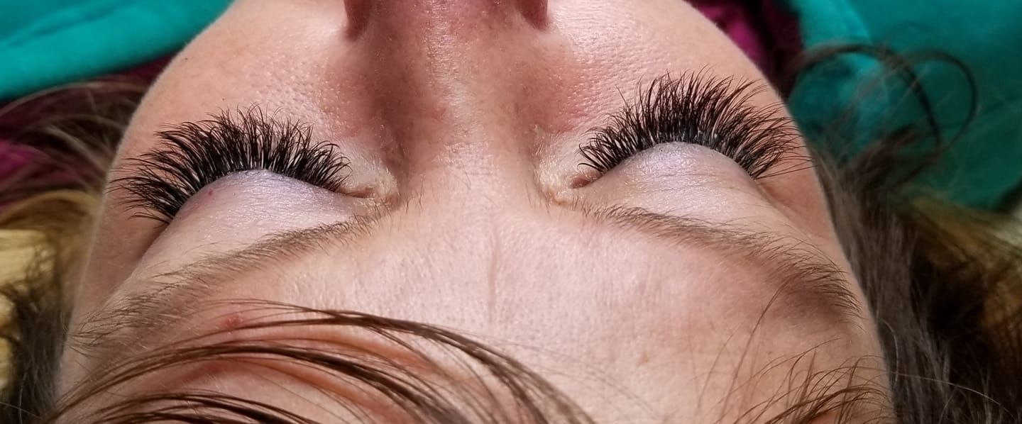 A close up of a woman 's face with long eyelashes.