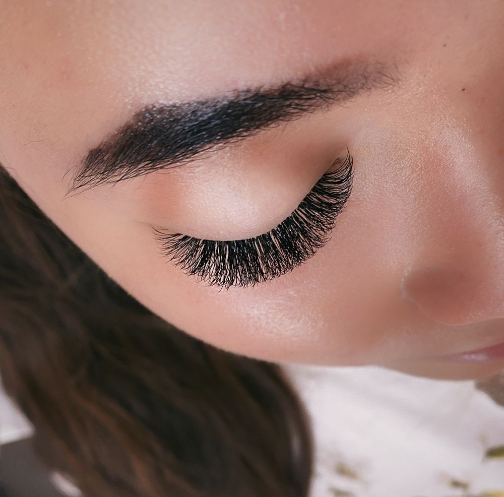 A close up of a woman 's eye with long eyelashes.