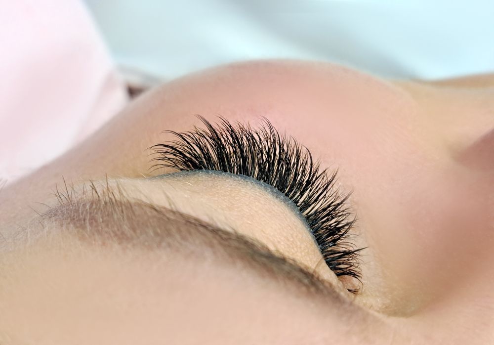 A close up of a woman 's eye with long eyelashes.