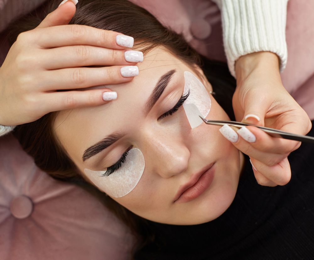 A woman is getting her eyelashes done at a beauty salon.