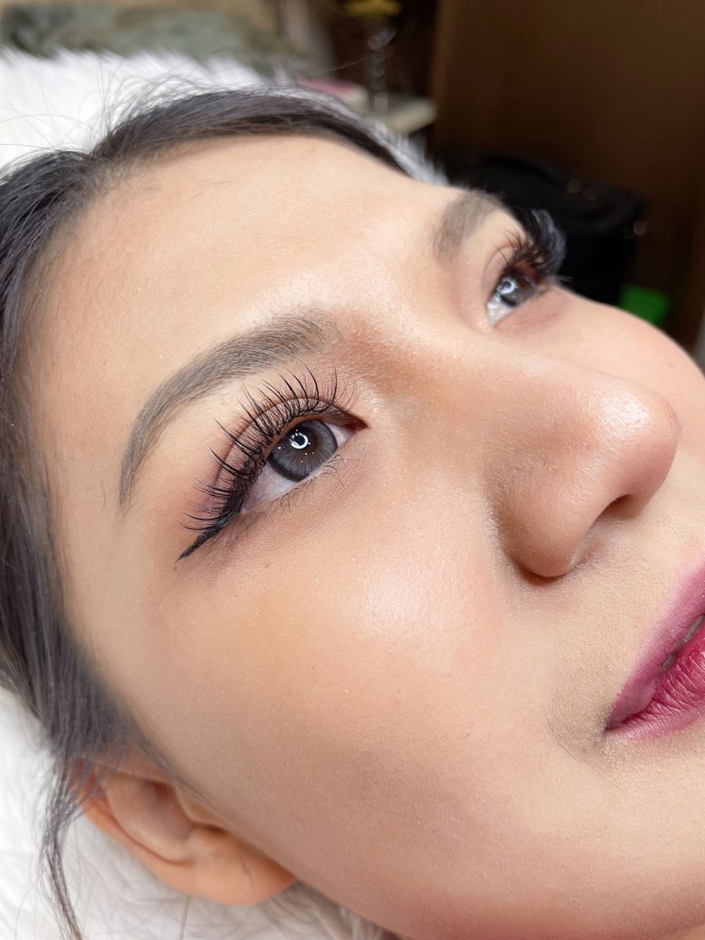 A close up of a woman 's face with long eyelashes.