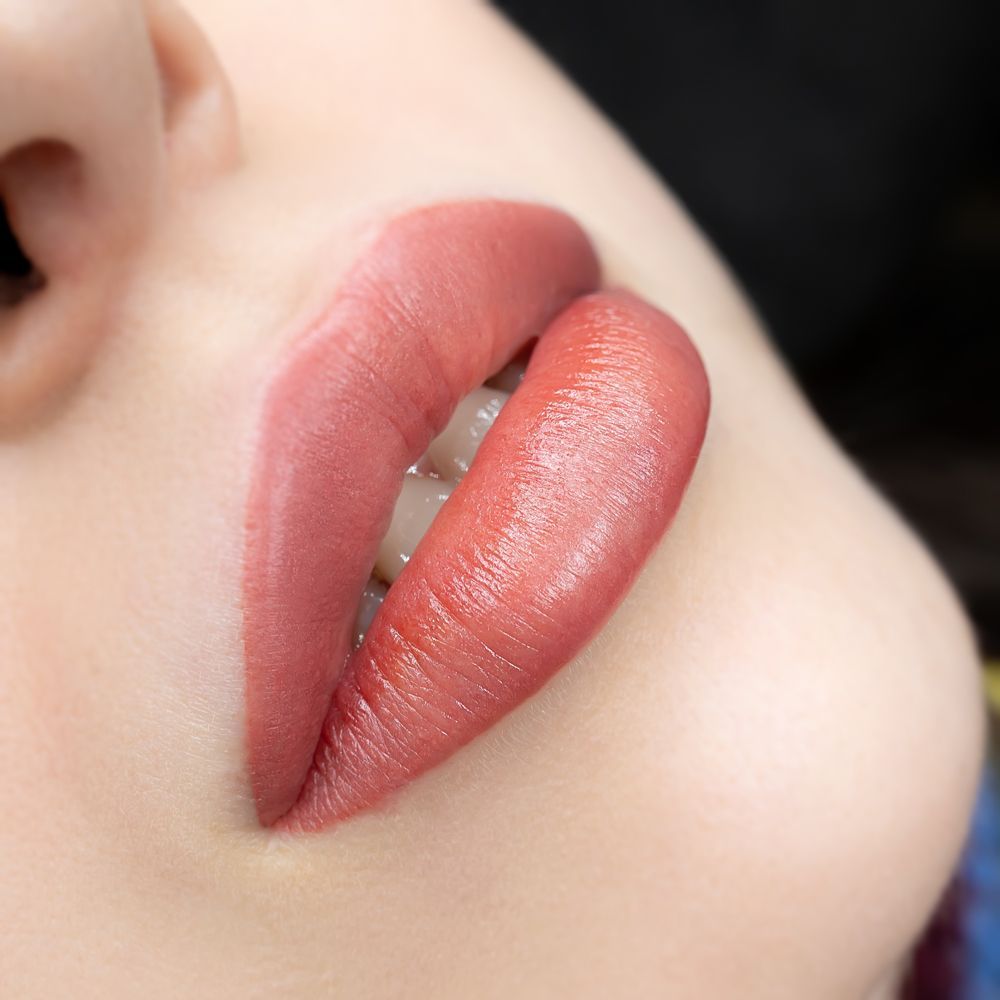 A close up of a woman 's lips with red lipstick.