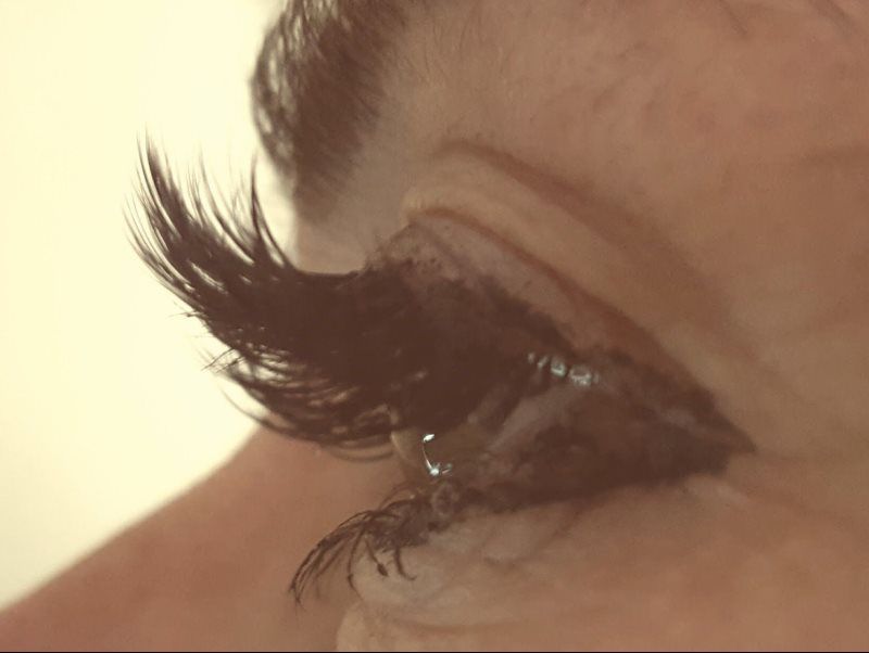 A close up of a woman 's eye with long eyelashes