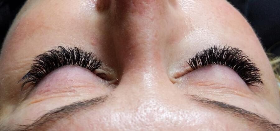 A close up of a woman 's face with long eyelashes.