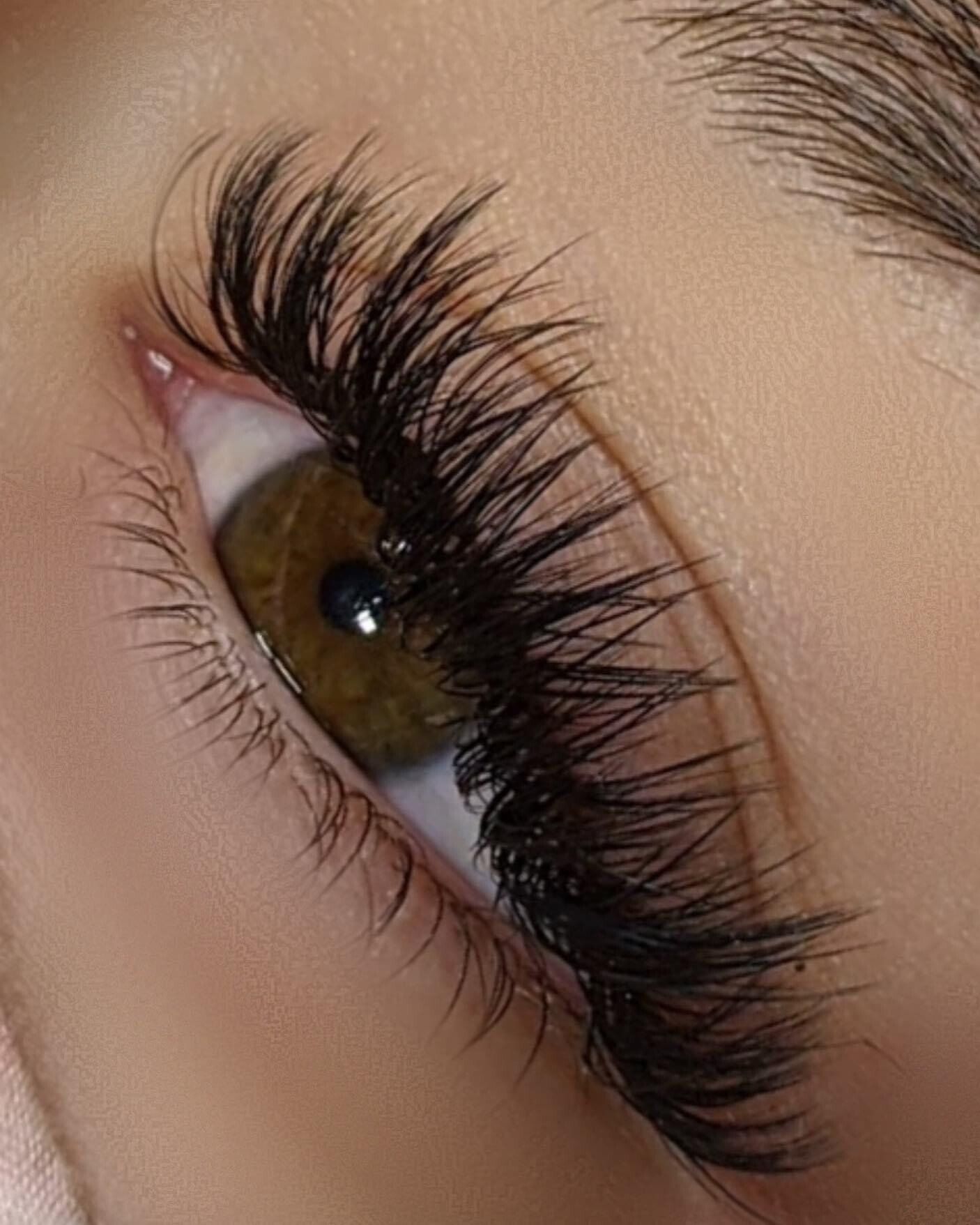 A close up of a woman 's eye with long eyelashes.