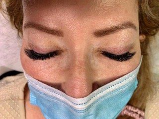 A close up of a woman wearing a mask with her eyes closed.