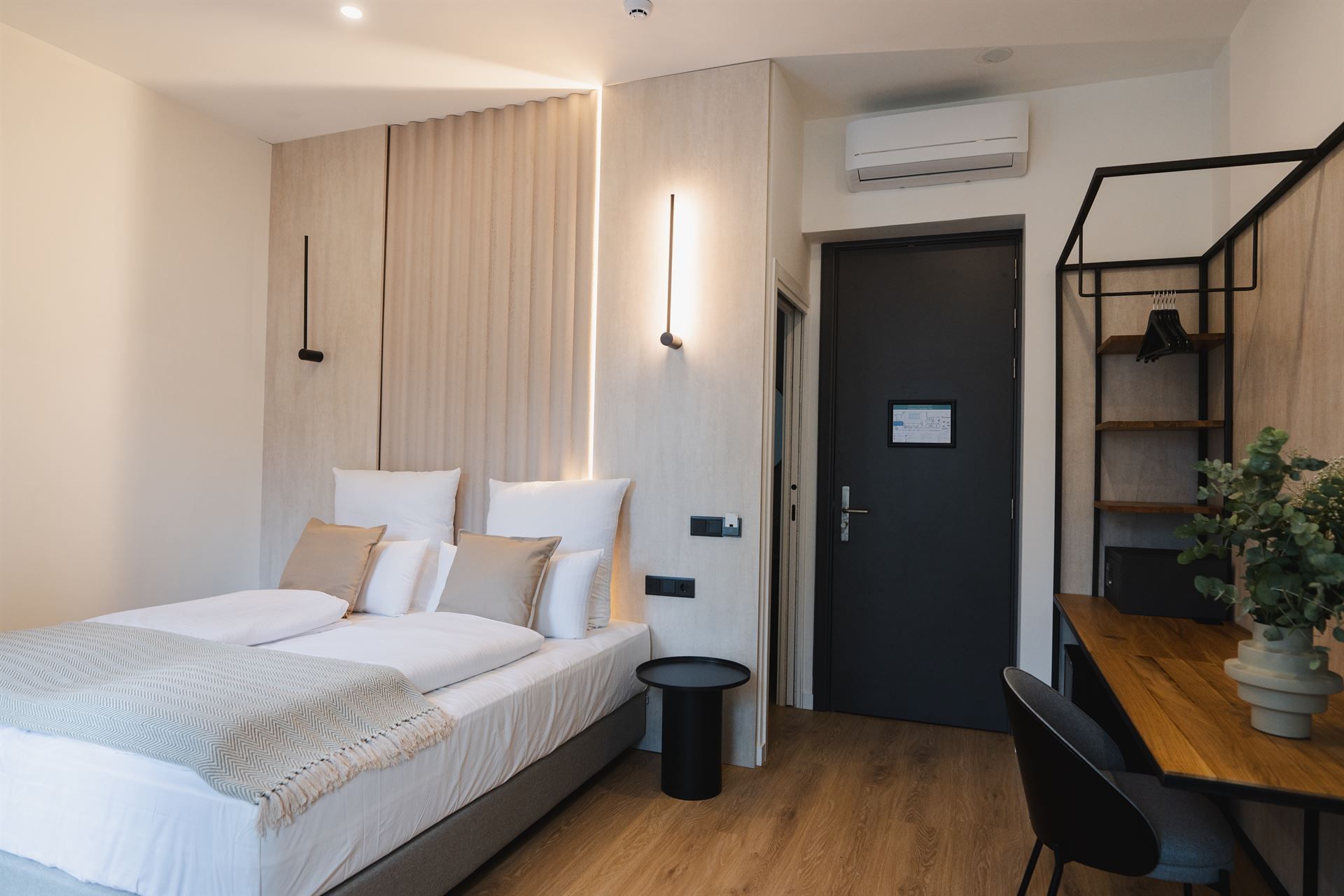 A hotel room with a bed , desk and chair.