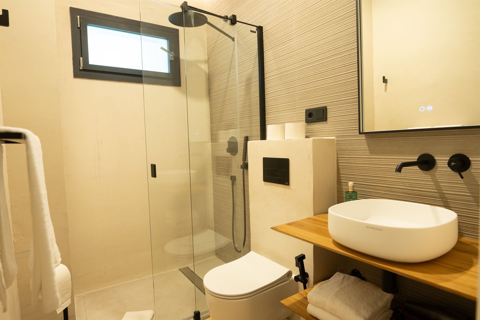 A bathroom with a toilet , sink and shower.