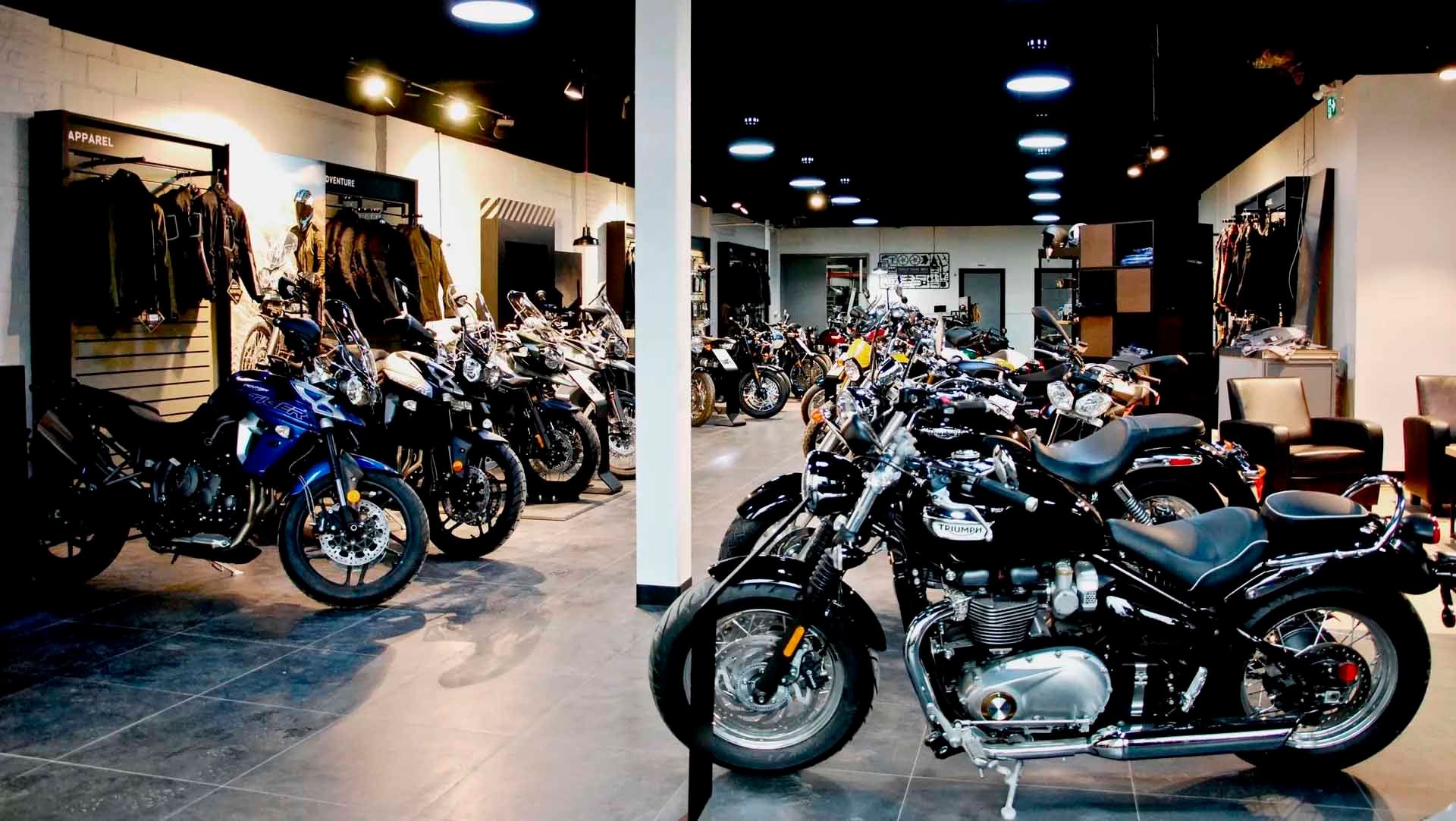 Salle d'exposition de motos présentant différents modèles, dont des modèles noirs et bleus.