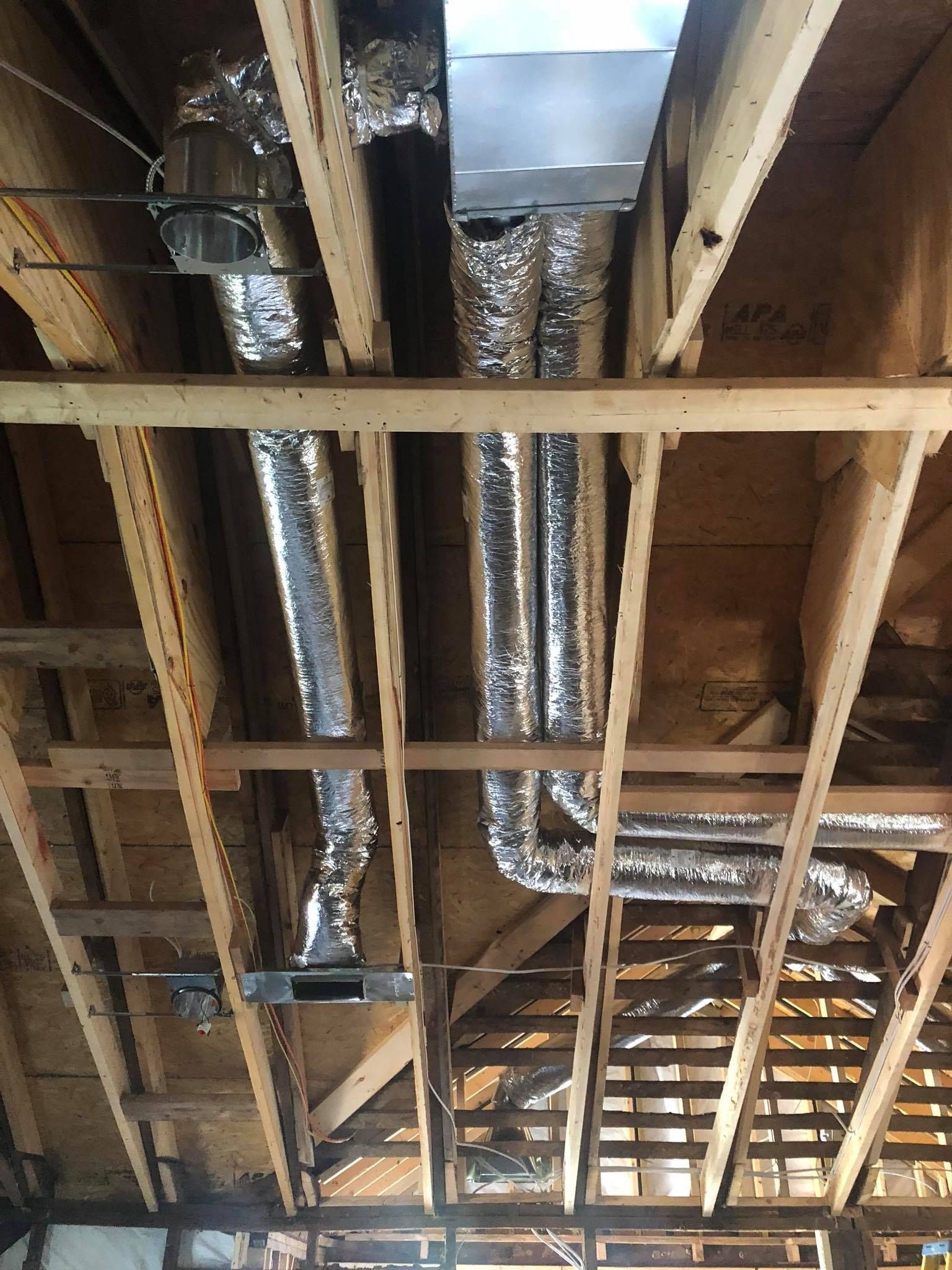A bunch of pipes are hanging from the ceiling of a building.