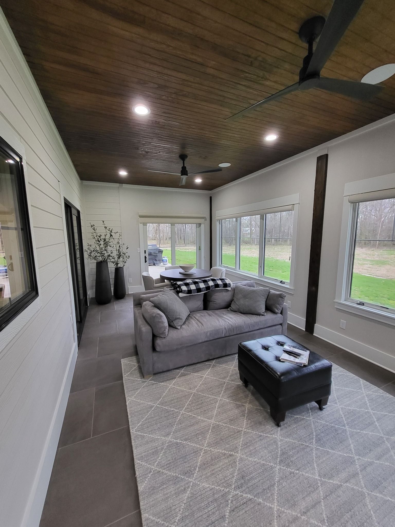 A living room with a couch , coffee table , and ceiling fan.