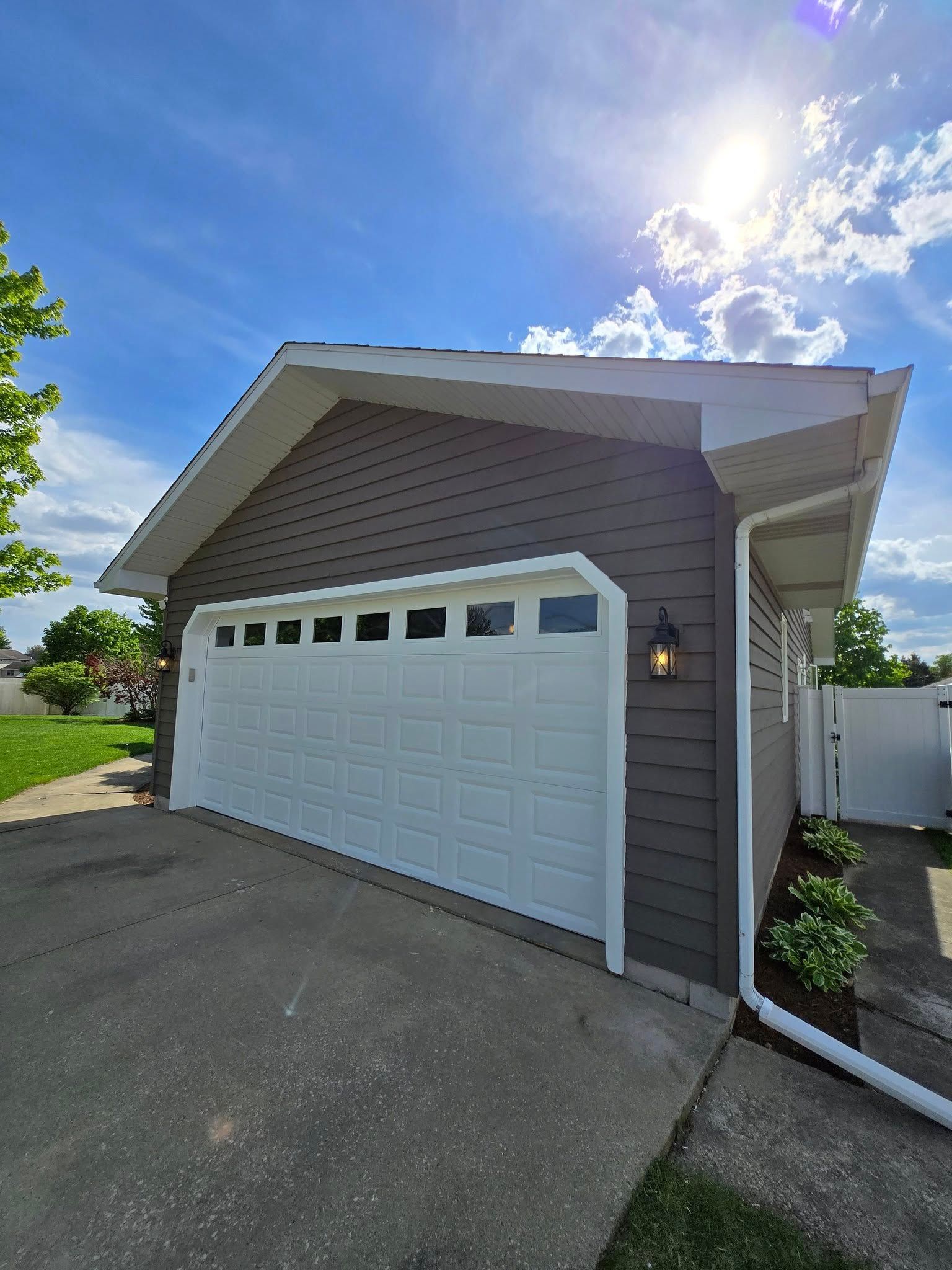 A garage with a white door and a blue sky in the background.