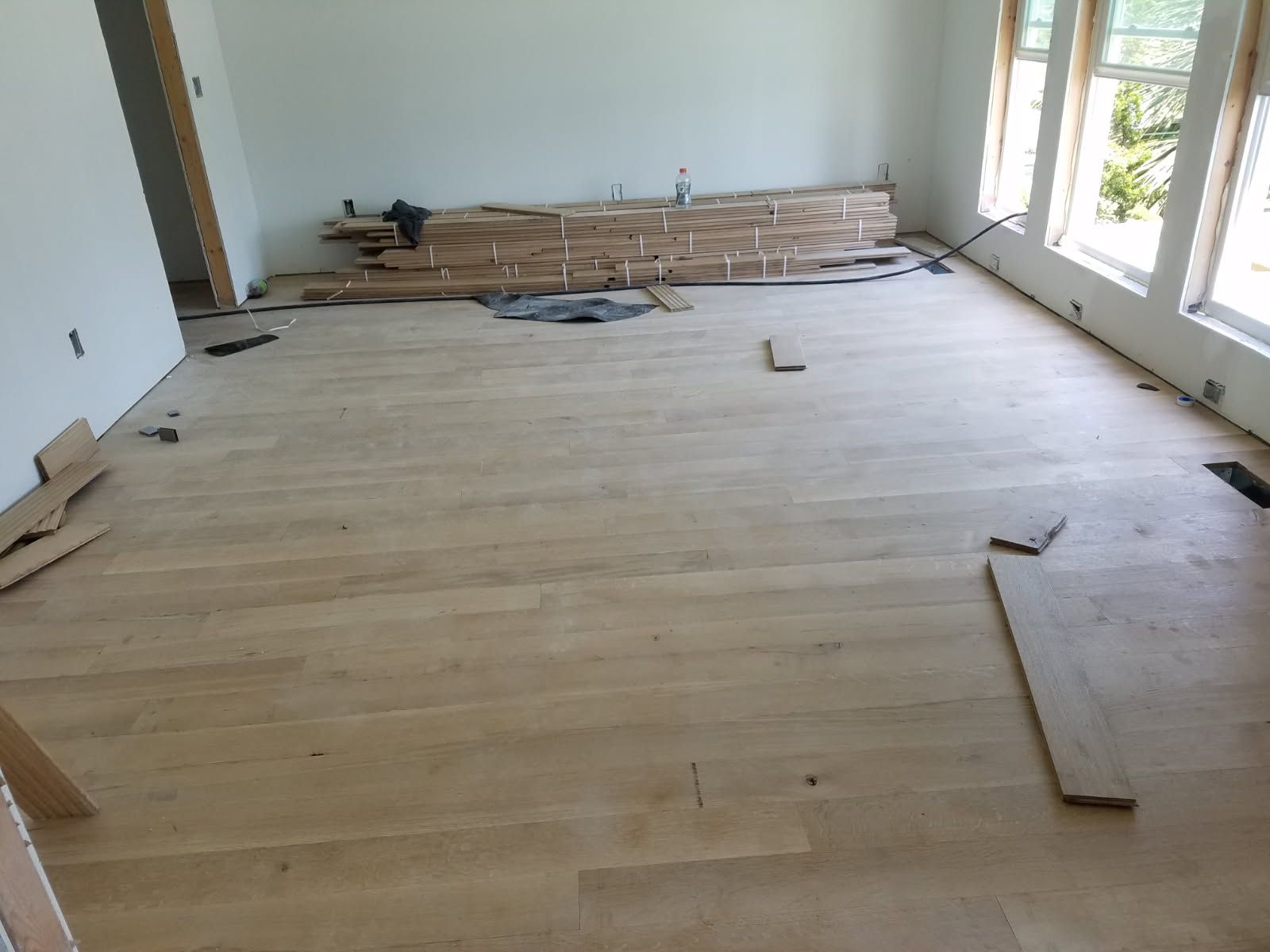 A room with a wooden floor and a lot of windows