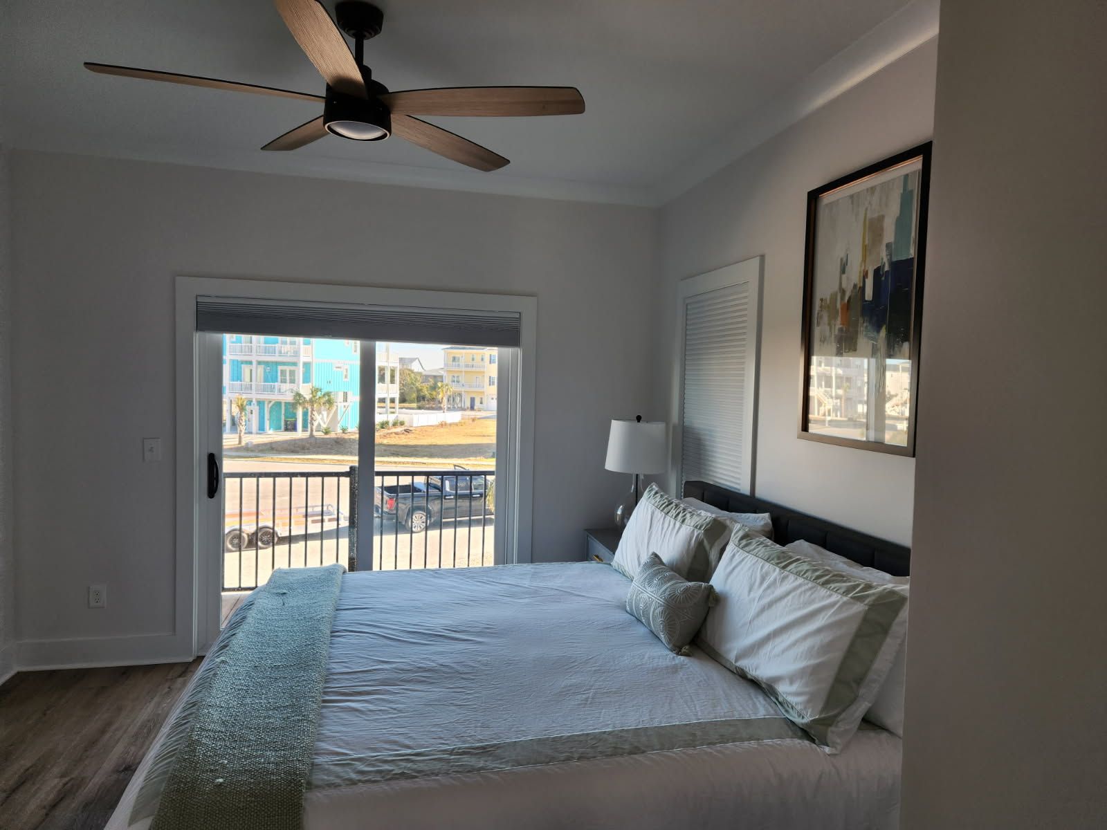 A bedroom with a large bed and a ceiling fan