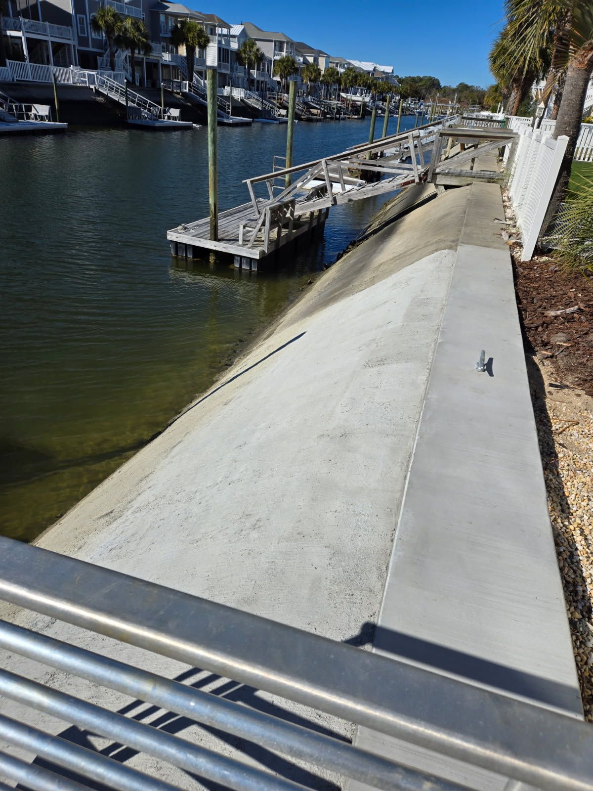 A concrete walkway leading to a body of water