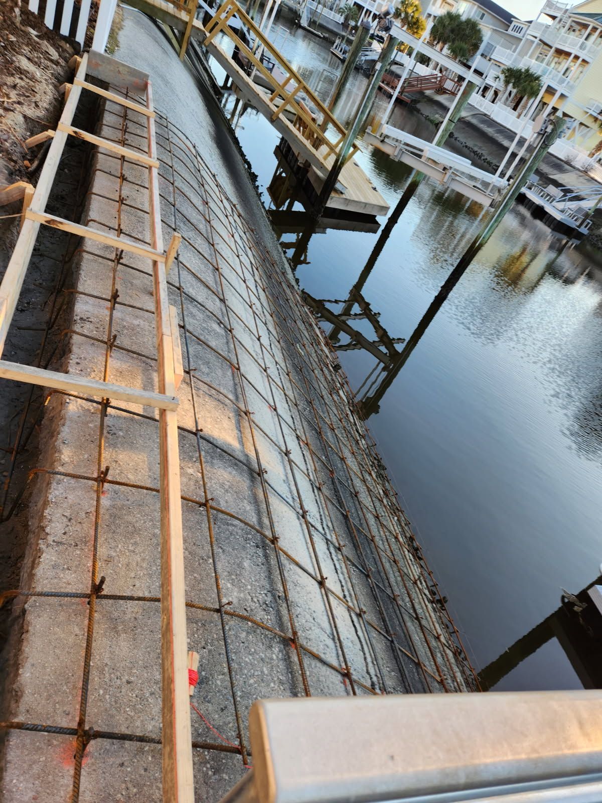 A concrete wall is being built next to a body of water.