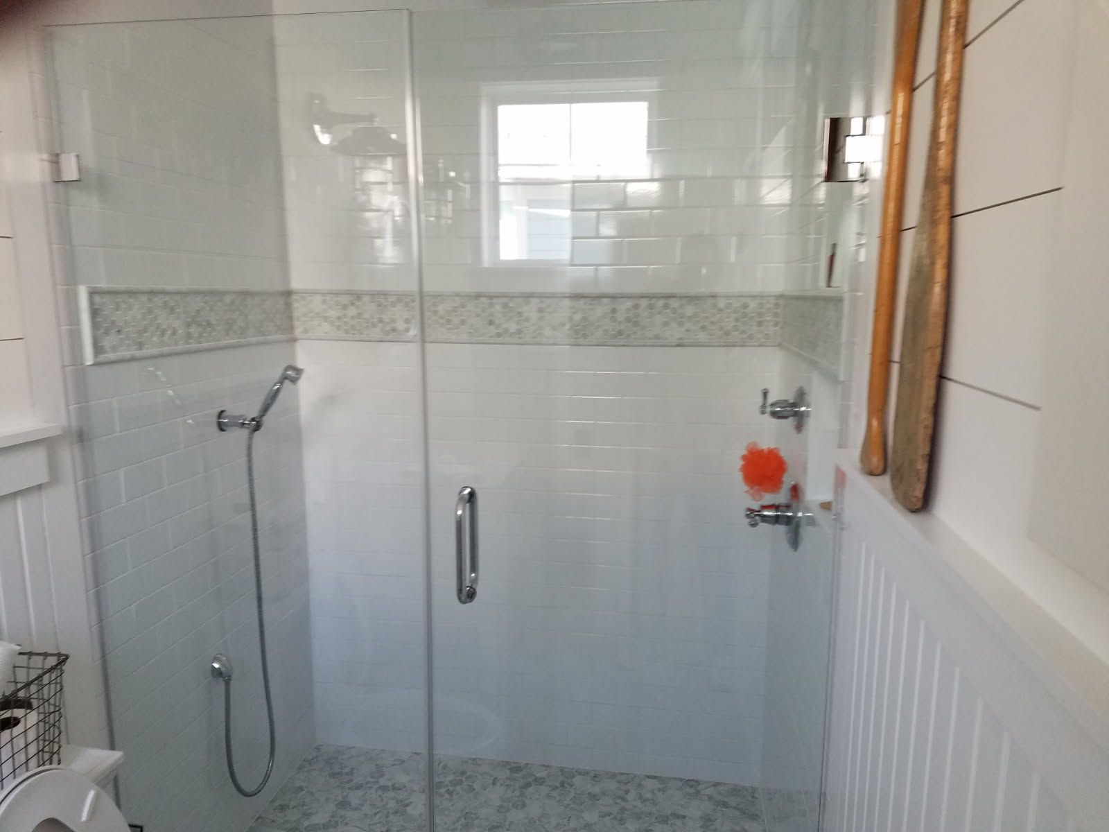 A bathroom with a walk in shower with a glass door.