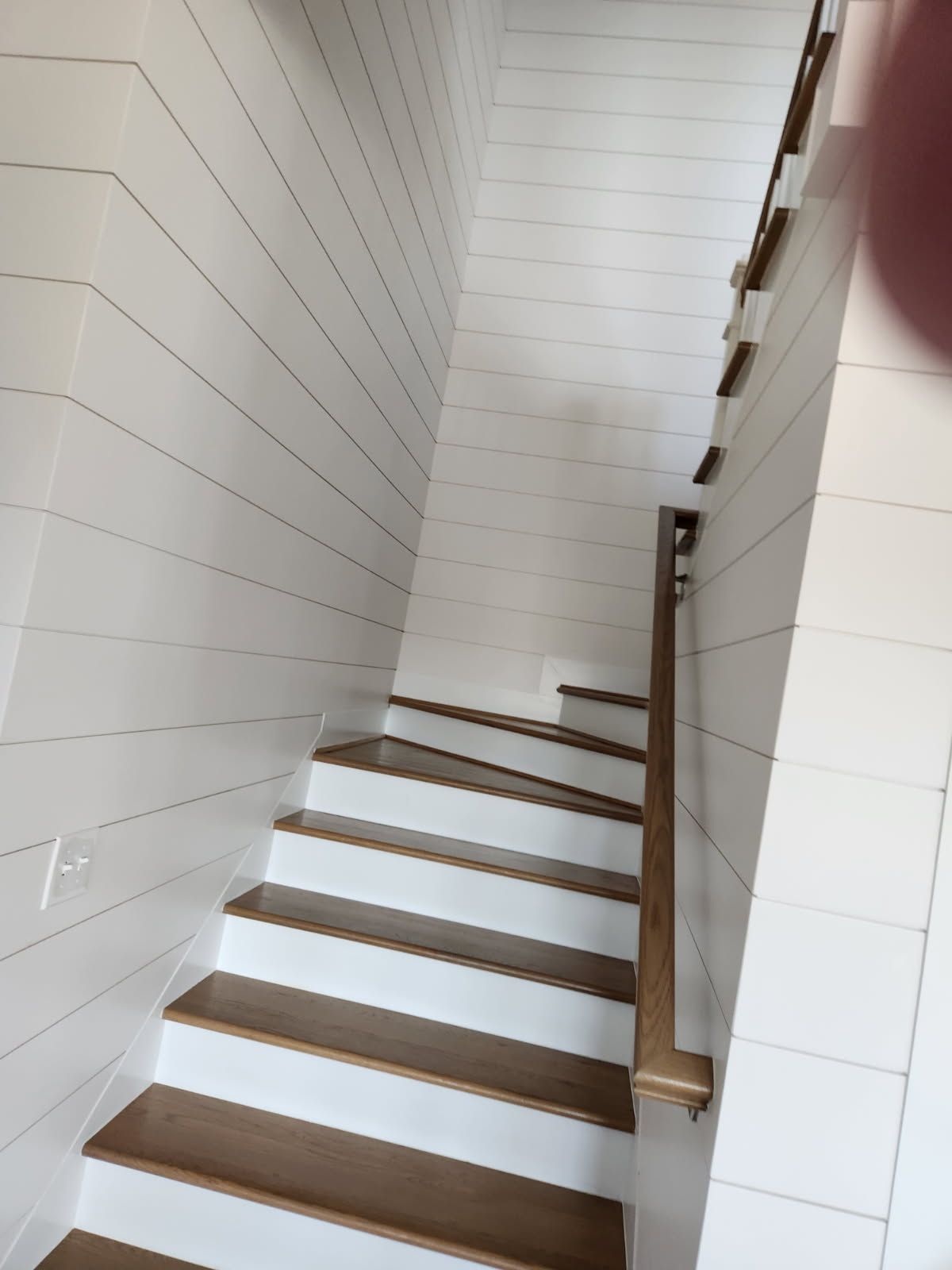 A staircase with wooden steps and white walls