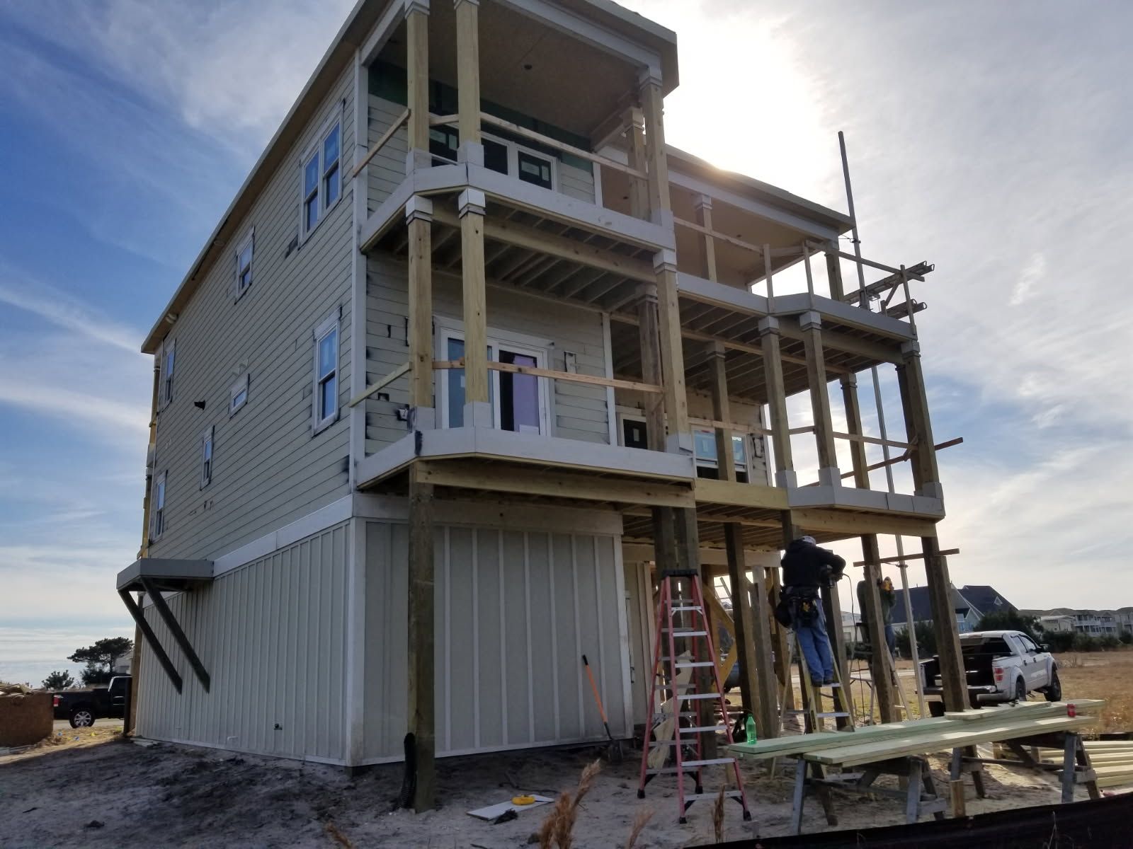 A house is being built on stilts on the beach.