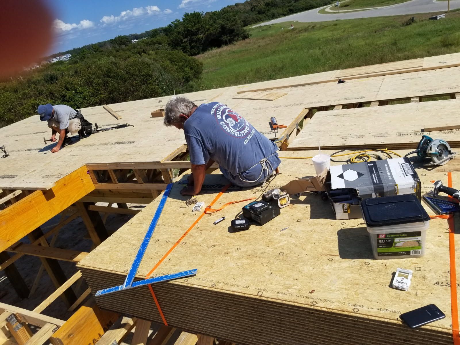 A man in a blue shirt is working on a roof