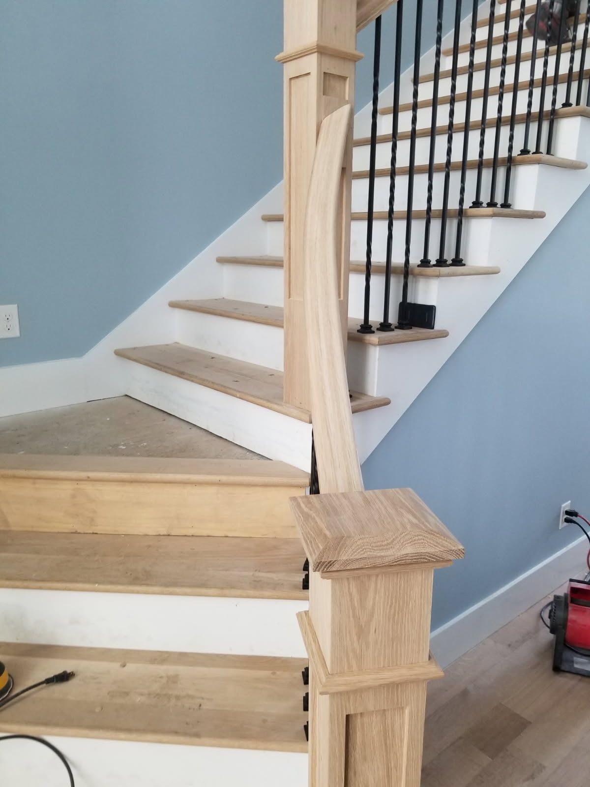 A wooden staircase with white steps and a metal railing