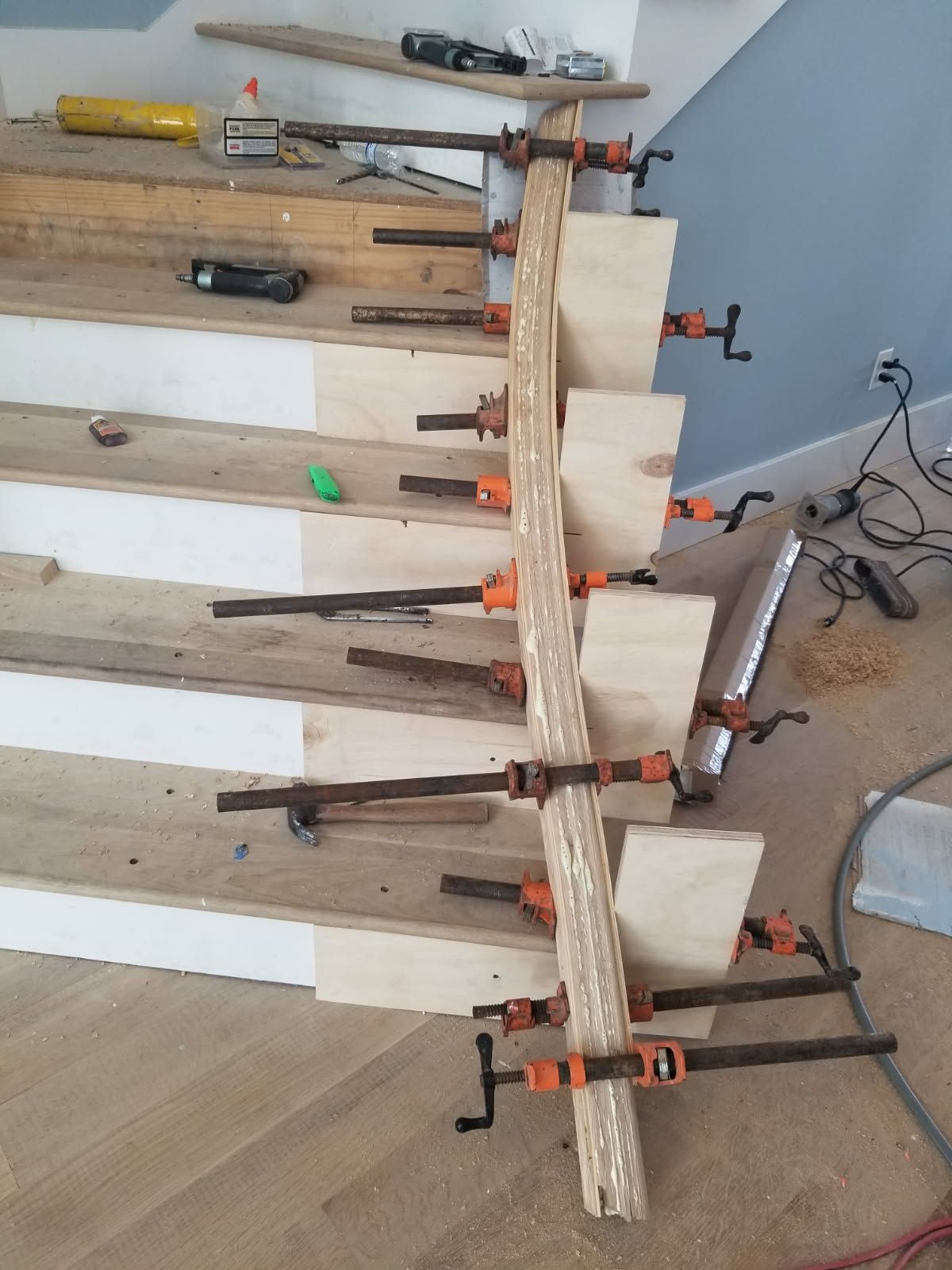 A wooden staircase is being built with clamps