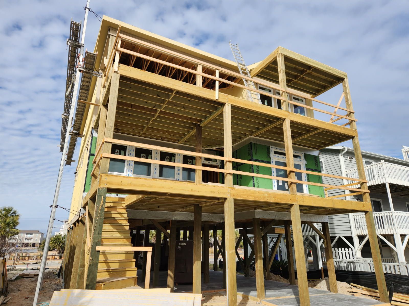 A house is being built on stilts with a wooden deck.